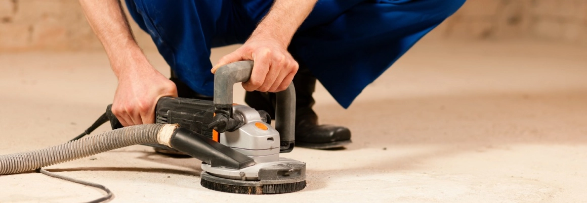 Person schleift Boden ab